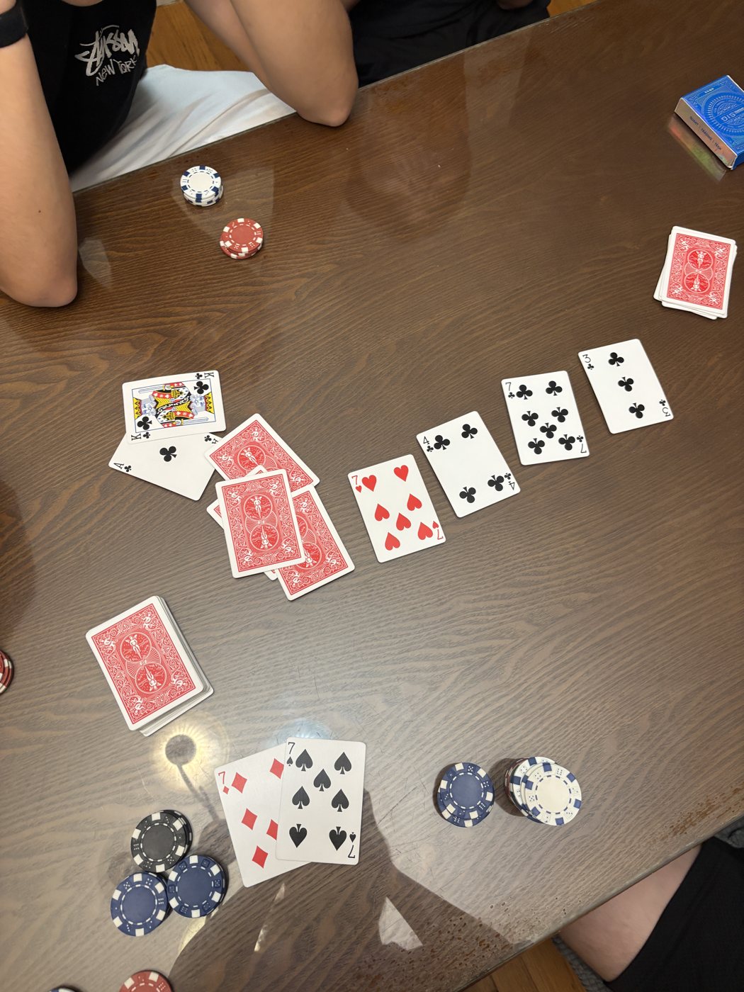 A poker hand in progress, chips stacked beside the cards