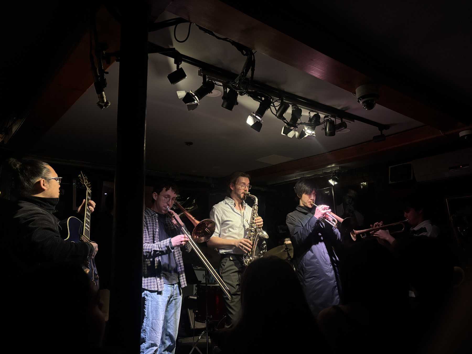 A live band playing at Smalls jazz club, horns up under the stage lights