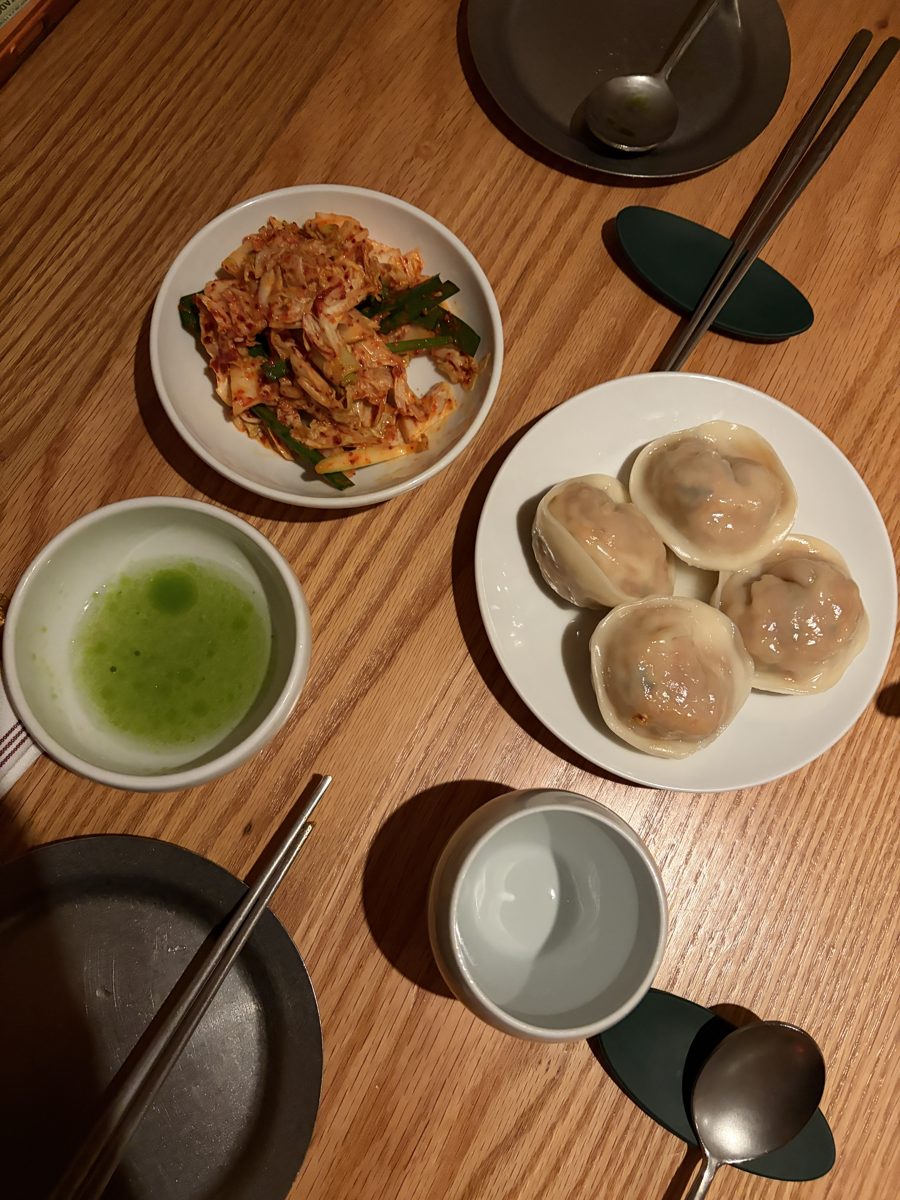 Soup dumplings and a matcha drink on a wooden table