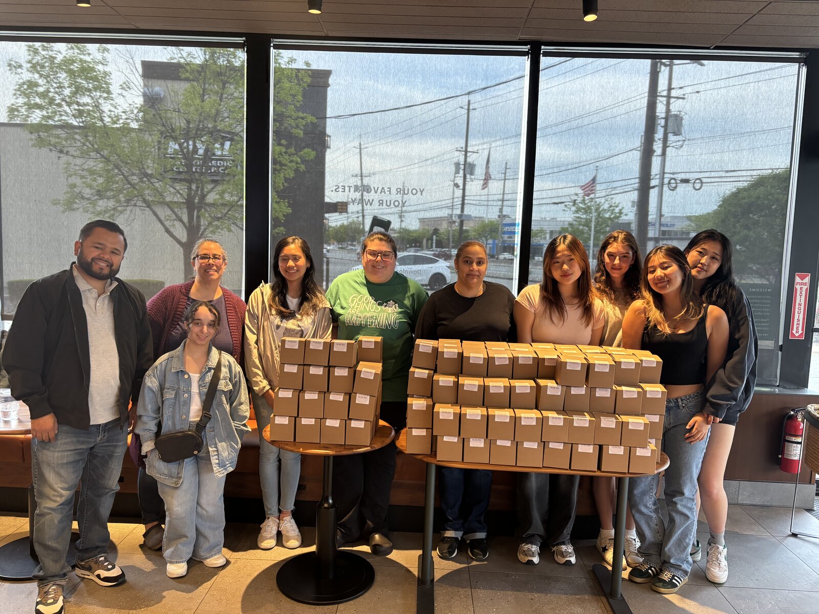 The For Her Flow team with product-drive collection boxes at a Starbucks partner location
