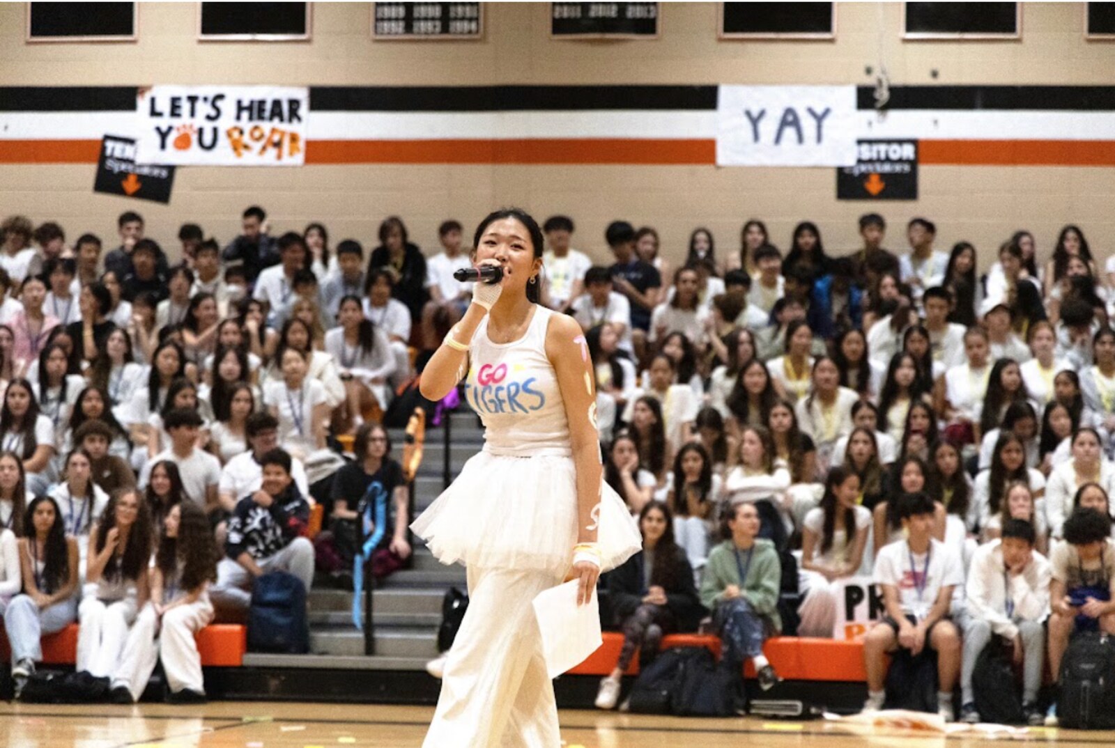 Grace MCing a pep rally in front of the student section